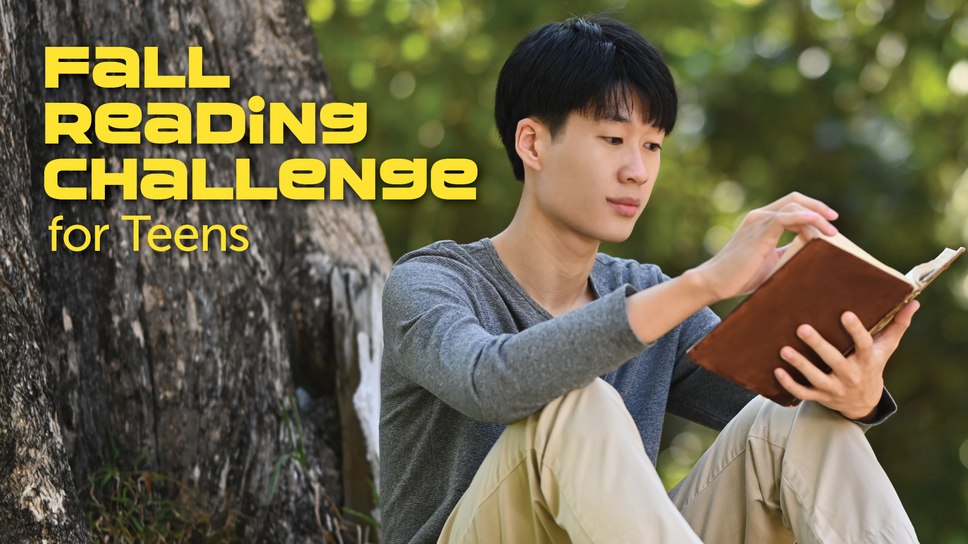 teen boy reading by a tree with reading challenge text