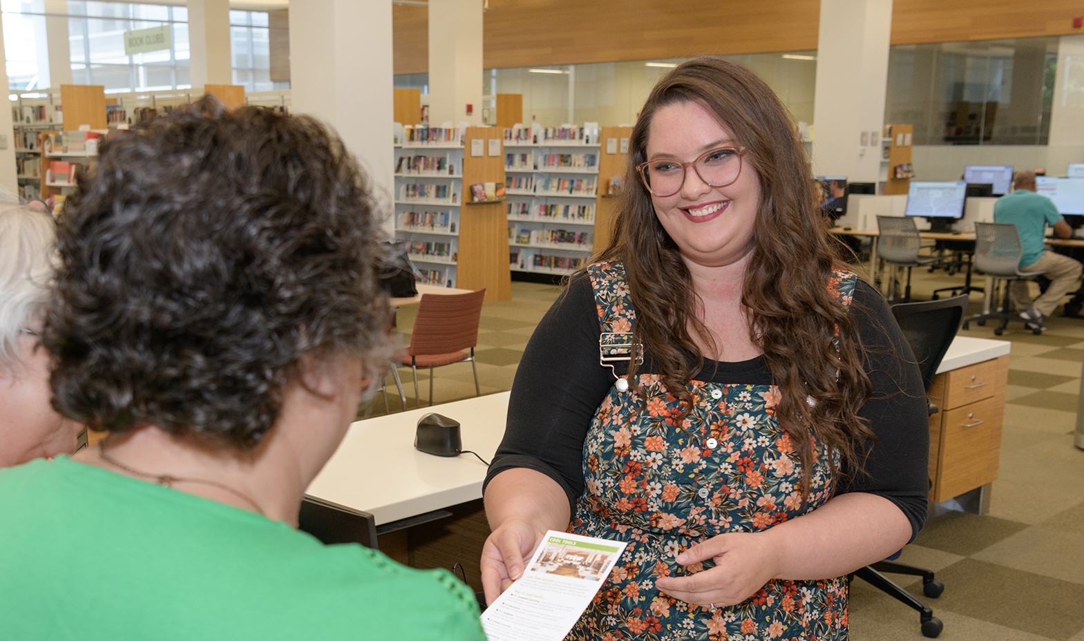 Smiling staff answer question, at the library
